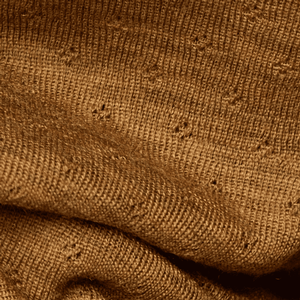 Detailaufnahme Eyelet-Muster des Jalfe Merino Dreiecktuchs in Senf